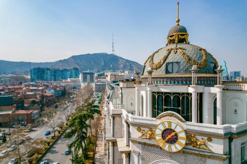 a building with a clock on the top of it at Zorba&Bond Boutique Hotel in Tbilisi City