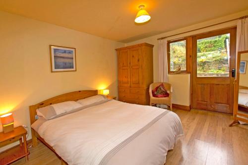 a bedroom with a large white bed and a window at Uplands Newport, Pembrokeshire in Newport Pembrokeshire