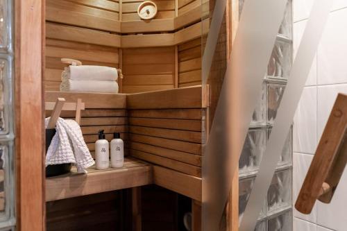 a small bathroom with wooden walls and towels at Cozy Studio with private Sauna in Helsinki