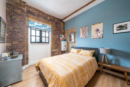 a bedroom with a bed and a brick wall at ALTIDO Stylish flat near London Bridge in London