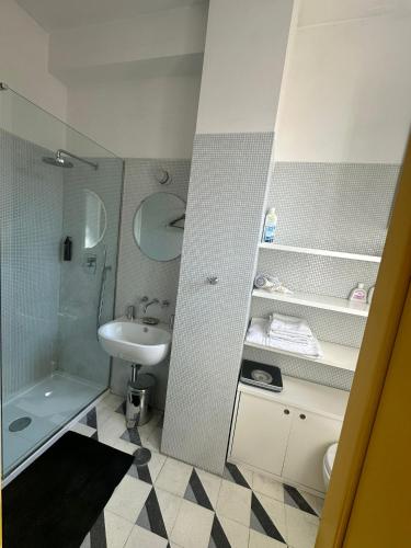 La salle de bains blanche est pourvue d'un lavabo et d'une douche. dans l'établissement Maison San Lorenzo Roma, à Rome