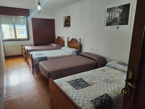 eine Gruppe von Betten in einem Zimmer in der Unterkunft QUINTA ANDAINA in Sigüeiro