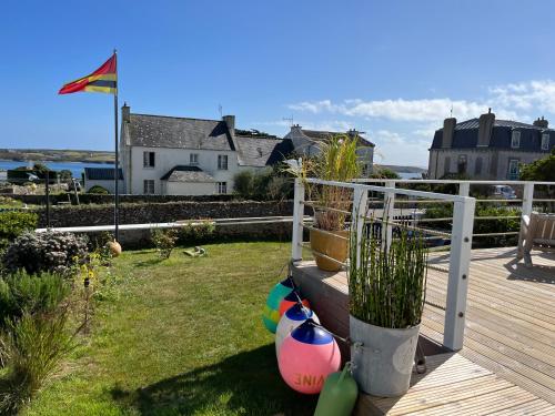 a deck with plants and a fence with a yard at L'Atelier de Mézareun in Ouessant