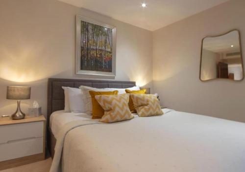 a bedroom with a white bed with pillows and a mirror at Westminster 1 bed apt with terrace in London