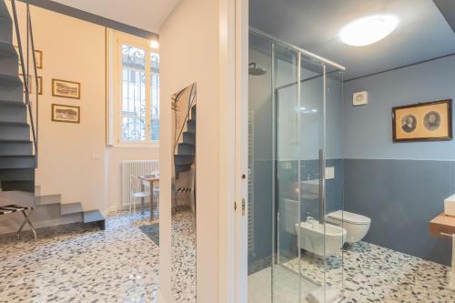 a bathroom with a glass shower and a toilet at Cinque Giornate 70 Suites by Rent All Como in Como