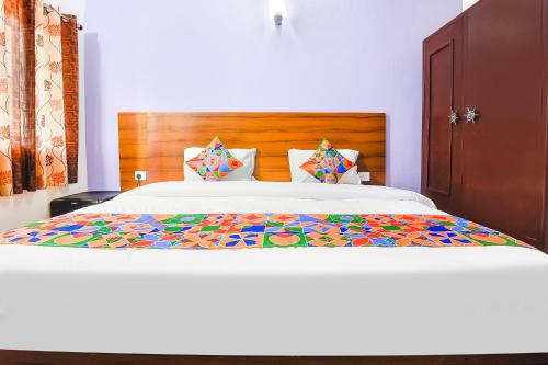 a bedroom with a large bed with a wooden headboard at FabHotel Angelo's Inn in Calangute