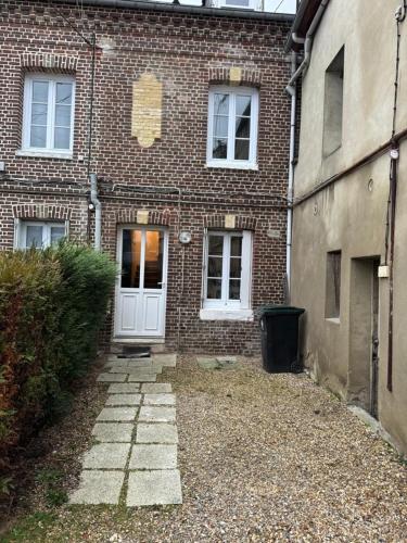 - un bâtiment en briques avec une porte blanche devant dans l'établissement Maison Triplex du jardin des plantes, à Rouen