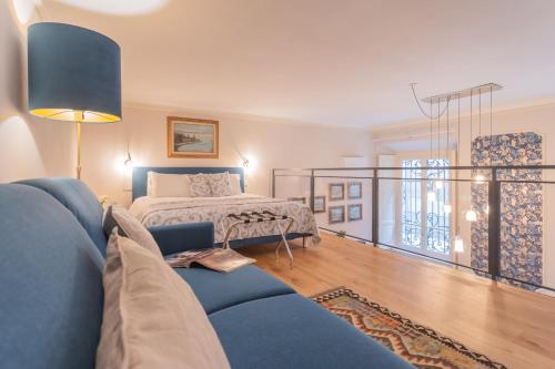 a living room with a bed and a blue couch at Cinque Giornate 70 Suites by Rent All Como in Como