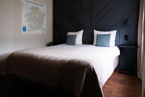 a bedroom with a large bed with blue pillows at Porta Cité in Maasmechelen