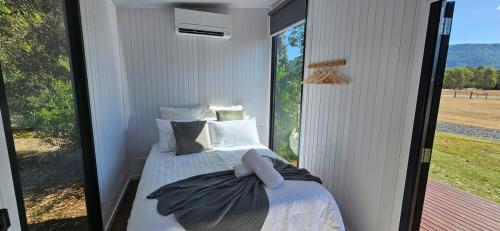 a bedroom with a bed and a large window at Halls Haven Tiny House 1 in Halls Gap