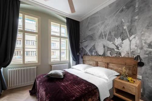 ein Schlafzimmer mit einem Bett und einer großen Wand in der Unterkunft Hidden jewel - Right in the centre of Prague in Prag