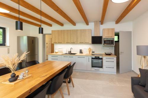 a kitchen and dining room with a wooden table and chairs at Apartmán Smraďavka in Buchlovice
