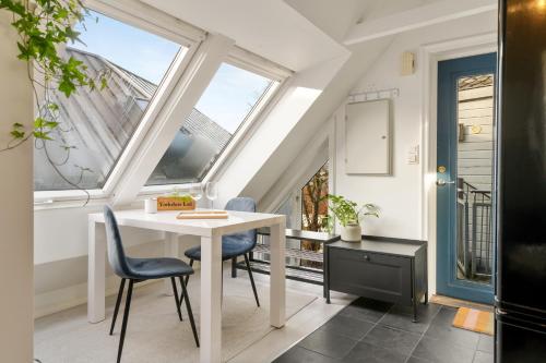 a room with a table and chairs and windows at Dinbnb Apartments I 100 meters from Bryggen I Self check-in I Coffee + in Bergen