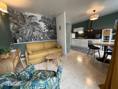 un salon avec un canapé et une cuisine dans l'établissement Beau F2 rénové au coeur de Caen, à Caen