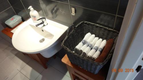 a bathroom with a sink and a basket of towels at Apartament Slupsk in Słupsk