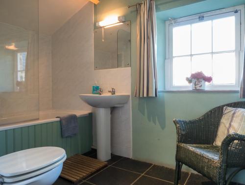 a bathroom with a sink and a toilet and a window at Treseissyllt Hafod St Nicholas in Saint Nicholas