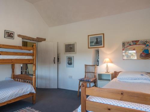 a bedroom with two bunk beds and a chair at Treseissyllt Hafod St Nicholas in Saint Nicholas