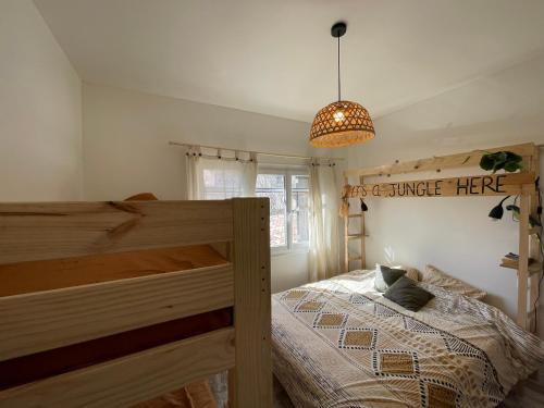 - une chambre avec un lit en bois et une lampe pendant dans l'établissement Vista Mare- proche plage et commerces - 8 pers, à Sari-Solenzara