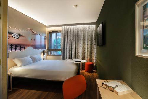 een hotelkamer met een wit bed en een raam bij ibis Styles Clermont-Ferrand Aéroport in Clermont-Ferrand