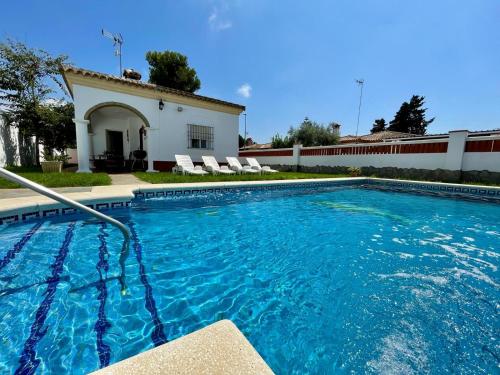 a swimming pool in front of a house at Chalet Manku in Chiclana de la Frontera
