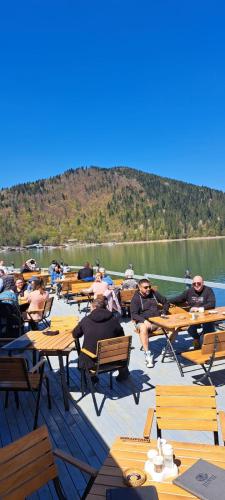 a group of people sitting at tables on a boat at Hotel Pescarus Port Bicaz in Bicaz