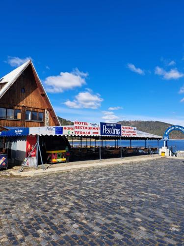 a building with signs on the side of it at Hotel Pescarus Port Bicaz in Bicaz