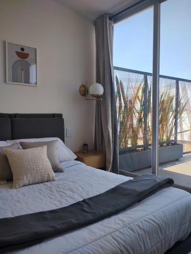 a bedroom with a large bed and a large window at Onmood Roma Norte by HiHab New Opening 2024 in Mexico City