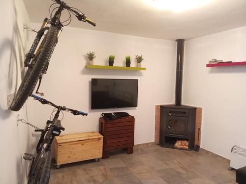 a living room with a tv and a bike hanging on the wall at Mi casica de Bogarra in Bogarra