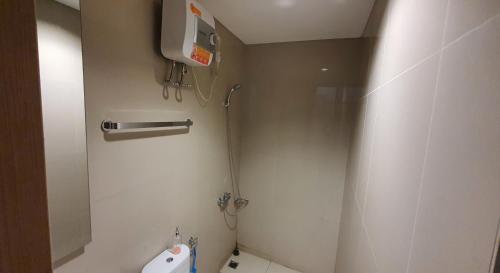 a bathroom with a shower and a toilet and a sink at TreeParkCity apartments by WinsHome in Tangerang