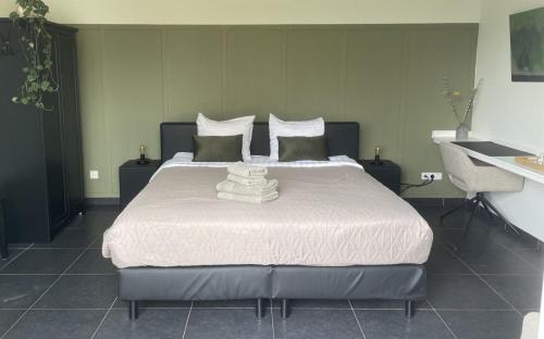 1 dormitorio con 1 cama con sábanas y almohadas blancas en Gasterij de Heihorst, en Someren