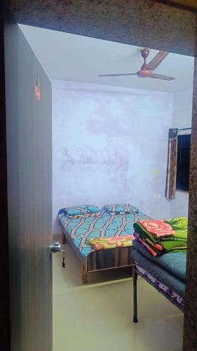 um pequeno quarto com uma cama e um tecto em shree swaminarayan vishranti bhawan em Dwarka