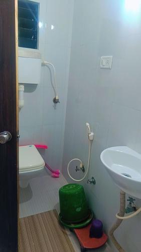 uma casa de banho com um lavatório e um WC em shree swaminarayan vishranti bhawan em Dwarka