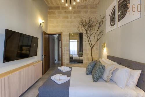 1 dormitorio con 1 cama grande y TV en la pared en Stunning 3BR Townhouse with Private Rooftop Access by 360 Estates, en Paola