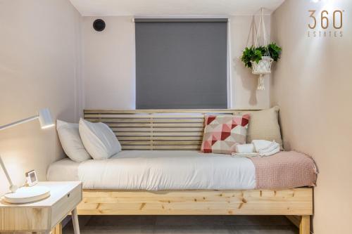 a bed in a room with a window and a table at Stunning 3BR Townhouse with Private Rooftop Access by 360 Estates in Paola