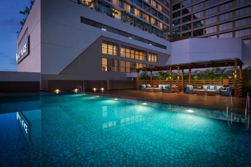 a swimming pool in front of a building at Hyatt Place Vadodara in Vadodara