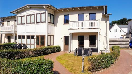 une grande maison blanche avec une allée dans l'établissement Familienfreundliches modernes Ferienhaus nahe zum Meer und zur Pier, à Heringsdorf