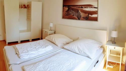 - un lit blanc avec 2 oreillers dans la chambre dans l'établissement Familienfreundliches modernes Ferienhaus nahe zum Meer und zur Pier, à Heringsdorf