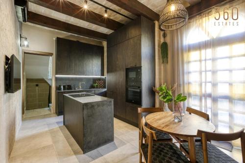 a kitchen with a wooden table and a dining room at Stunning 3BR Townhouse with Private Rooftop Access by 360 Estates in Paola