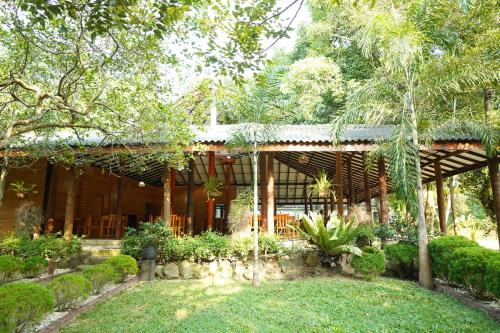 a wooden house with a garden in front of it at Lake Resort Bolgoda in Wadduwa