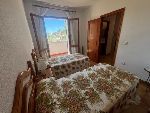 two beds in a room with a window at L´Escala in Denia