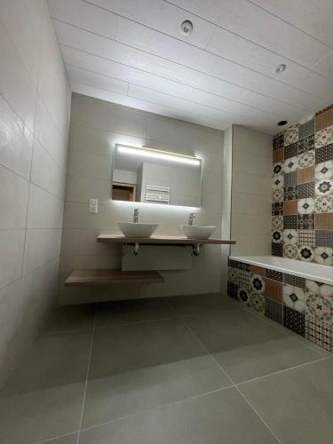 une salle de bain avec deux lavabos et un miroir dans l'établissement La petite fille des rivières, à Foncine-le-Bas