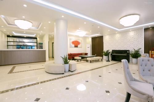 a lobby with white chairs and a fireplace at Hạ Long Legend Hotel in Ha Long