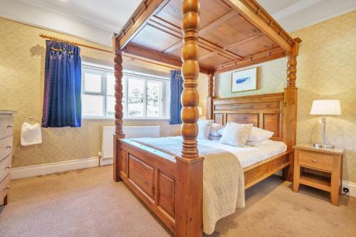 um quarto com uma cama de dossel em madeira num quarto em Alice Howe em Windermere