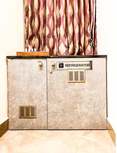 a refrigerator sitting in a room with a curtain at Shree Residency in Erode