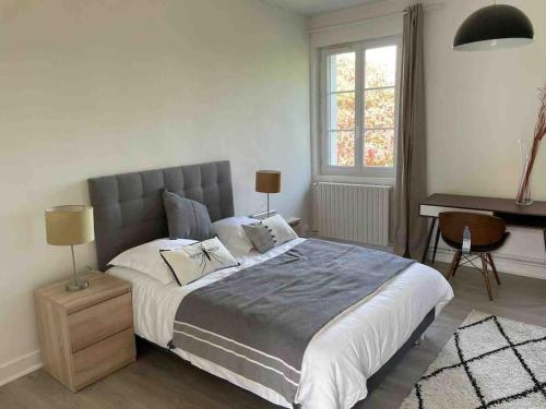 une chambre avec un grand lit et un bureau dans l'établissement Charmante maison de campagne, à Rugles