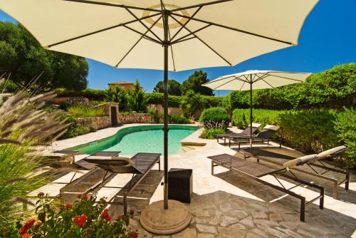 a pool with chairs and an umbrella next to a pool at VILLA ALENAR - Marratxi- Mallorca in La Cabaneta