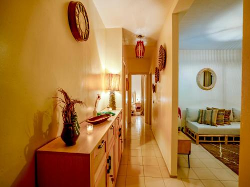 een keuken met een klok aan de muur en een woonkamer bij ALIYA LUXURY APARTMENT TAMANART 1-AGADIR in Agadir