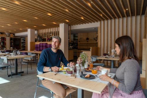 a man and woman sitting at a table in a restaurant at Hotel Nevada in Bormio