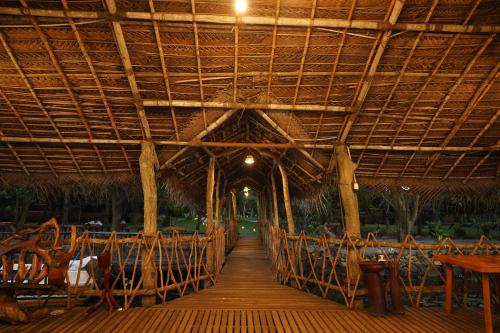 a wooden walkway in a restaurant with a large roof at Lake Resort Bolgoda in Wadduwa