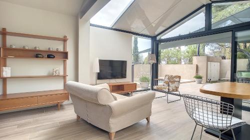 a living room with a chair and a television at Villa ALFONSA in Saint-Raphaël